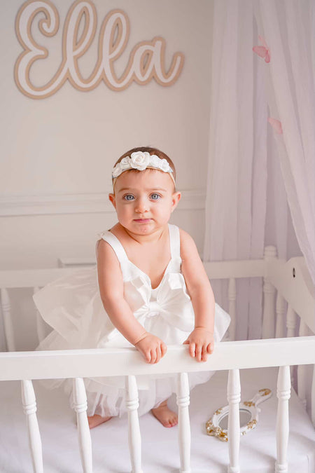 Baby girl wearing white bow flower girl dress Australia, adorable flower girl outfit for weddings and birthdays.