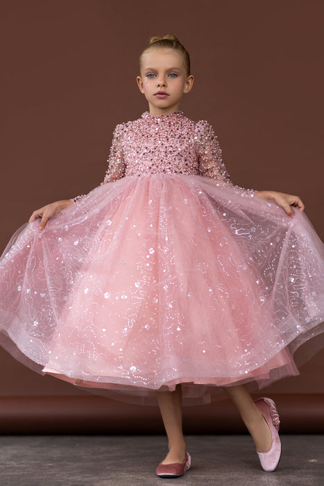 Girl twirling in pink sparkle dress with long sleeves and layered tulle skirt