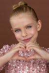 Close-up of neckline and pearl embellishment on pink sequin dress