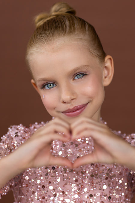 Close-up of neckline and pearl embellishment on pink sequin dress