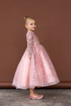 Side pose of girl wearing glittery pink dress with sequin details