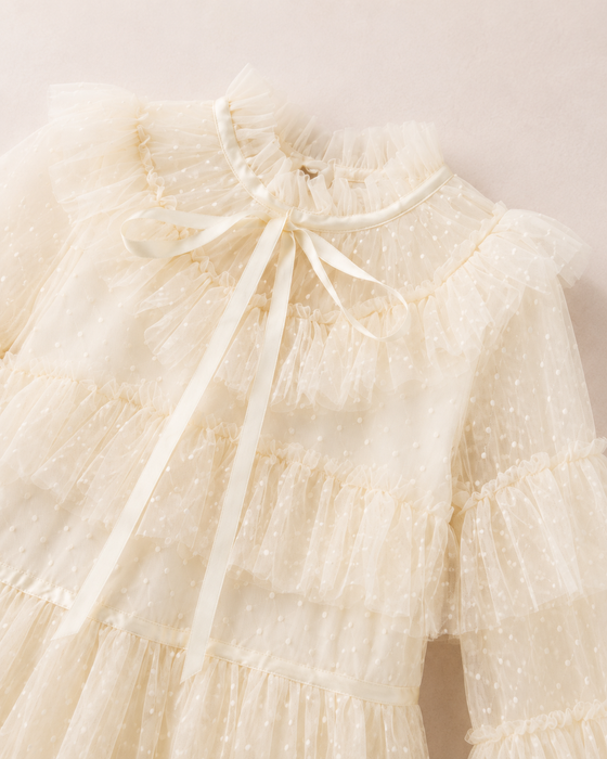 Bow neckline and dotted tulle detail on an ivory white girls party dress