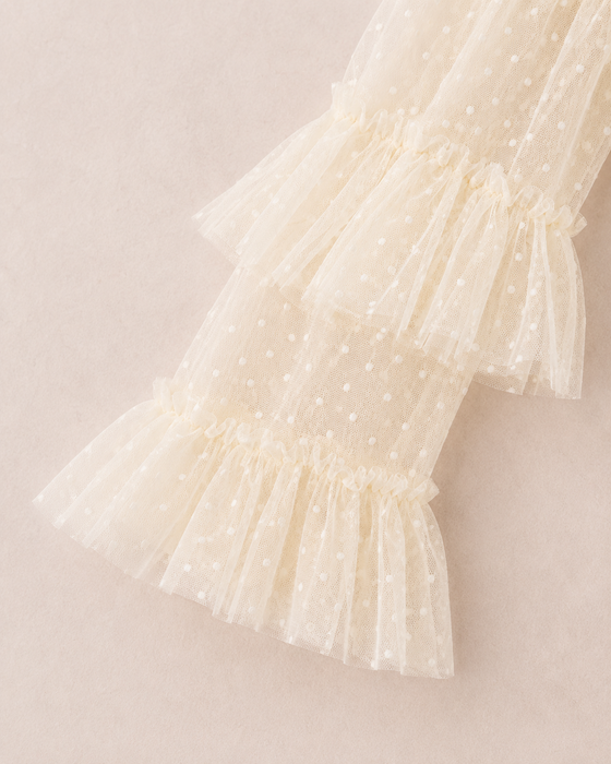 Long sheer tulle sleeve with layered ruffle details on a girls formal dress