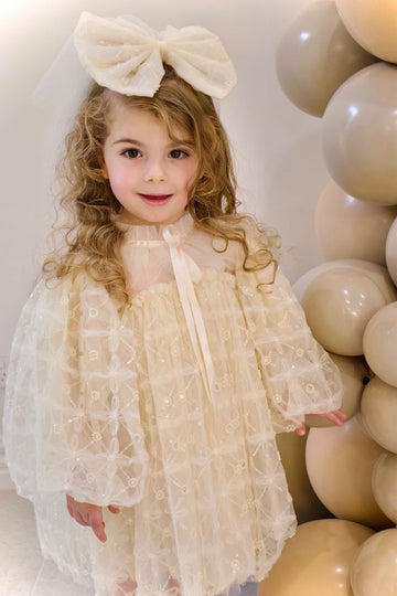 Cute girl wearing champagne flower girl dress with puff sleeves, stylish flower girl gown Australia.
