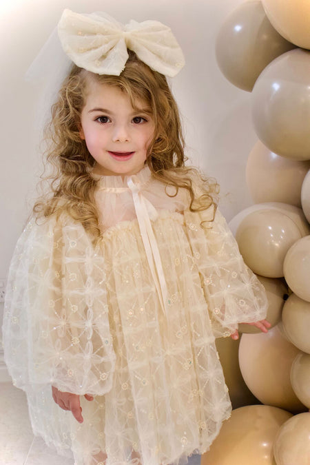 Cute girl wearing champagne flower girl dress with puff sleeves, stylish flower girl gown Australia.