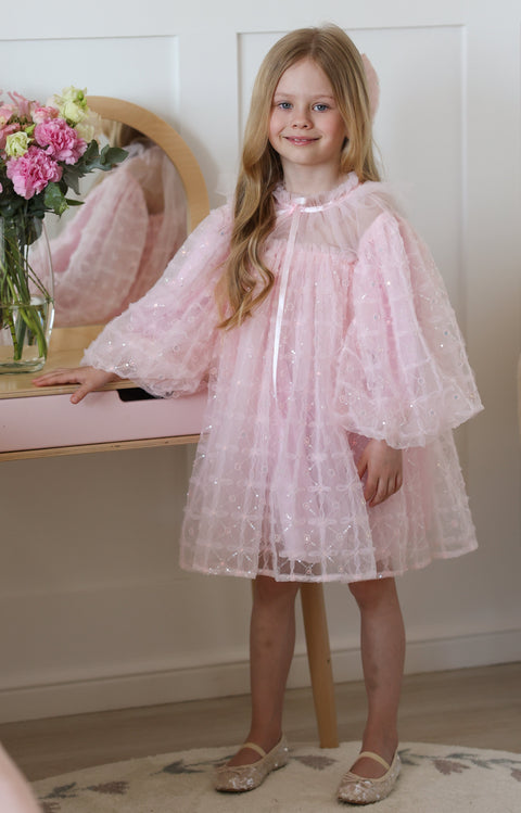 Girl in pink tutu dress with puff sleeves, elegant toddler birthday and flower girl outfit.