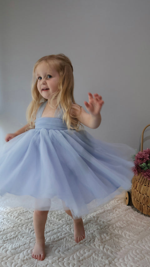 Toddler girl in blue bow tutu dress, twirling birthday and flower girl outfit.