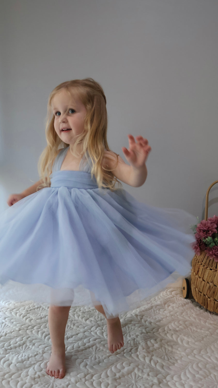 Toddler girl in blue bow tutu dress, twirling birthday and flower girl outfit.