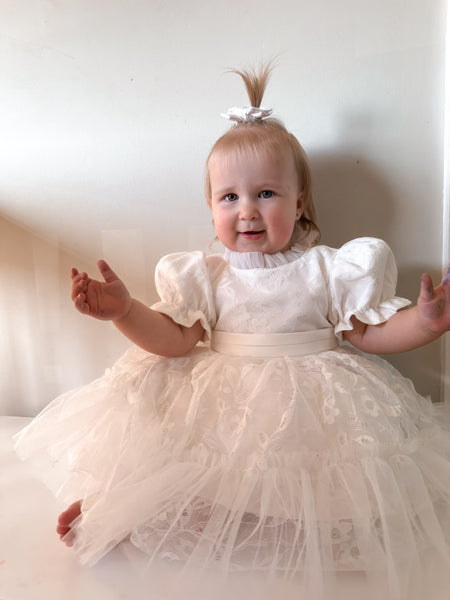 Baby girl in white puff sleeve flower girl outfit, adorable flower girl dress Australia.
