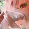 Close-up of the pink lining beneath the strawberry sequin tulle dress, held up to show the inner layer
