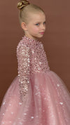 Girl in beaded pink party dress with long sleeves looking sideways