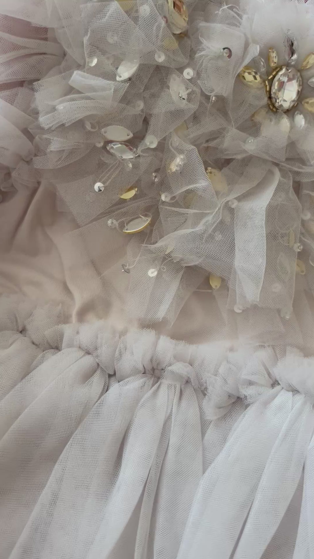 Close-up of shimmering sequins on grey tulle dress