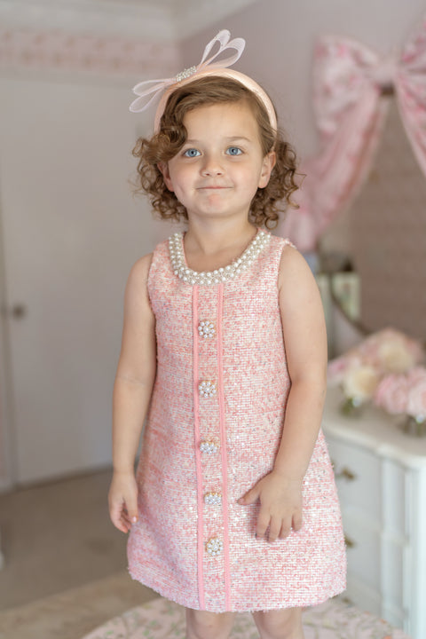 Girl wearing pink bouclé tweed dress with pearl buttons – luxury birthday outfit