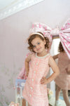 girl in sleeveless pink tweed dress with pearl collar for special occasion